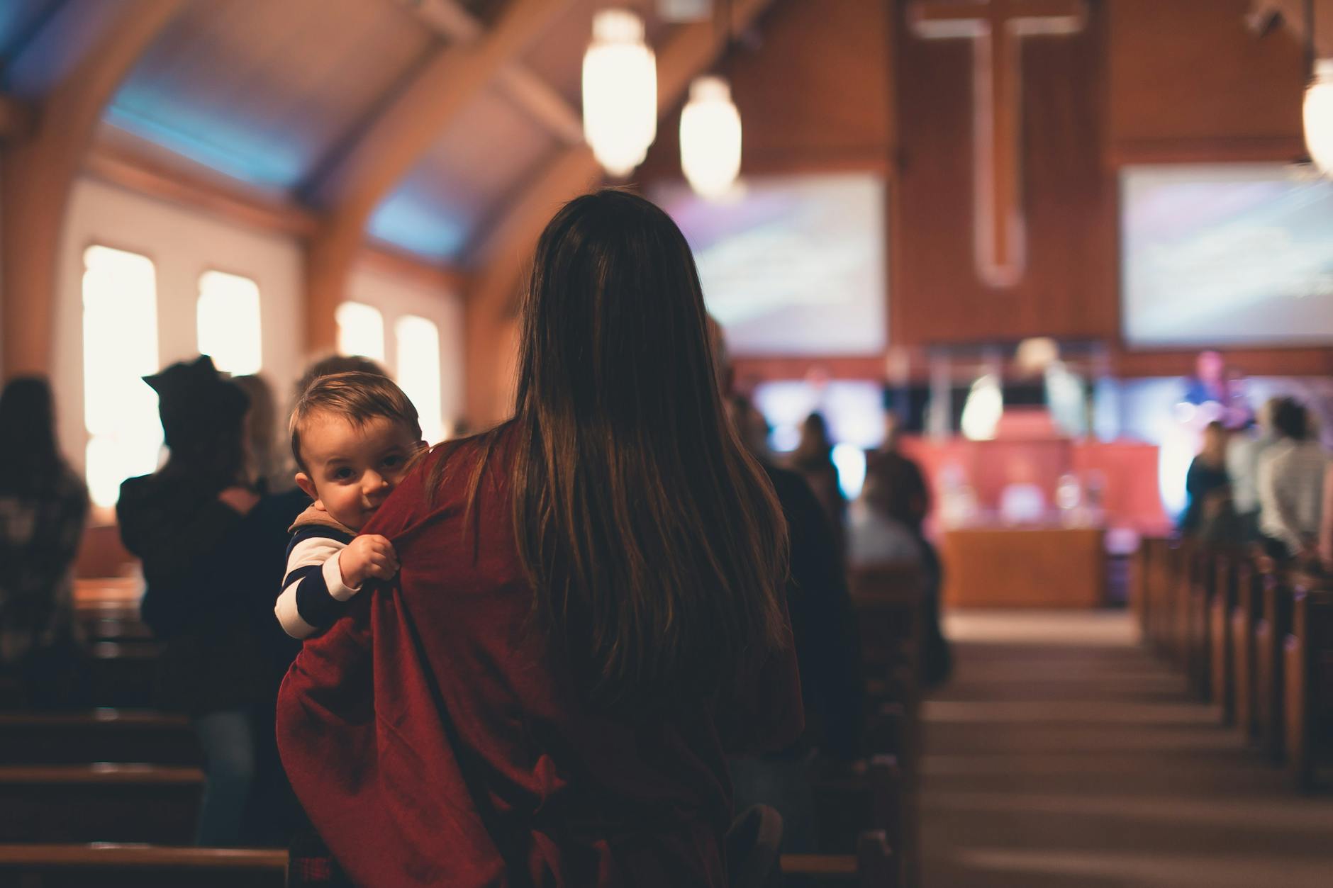 a mother carrying a child inside a church